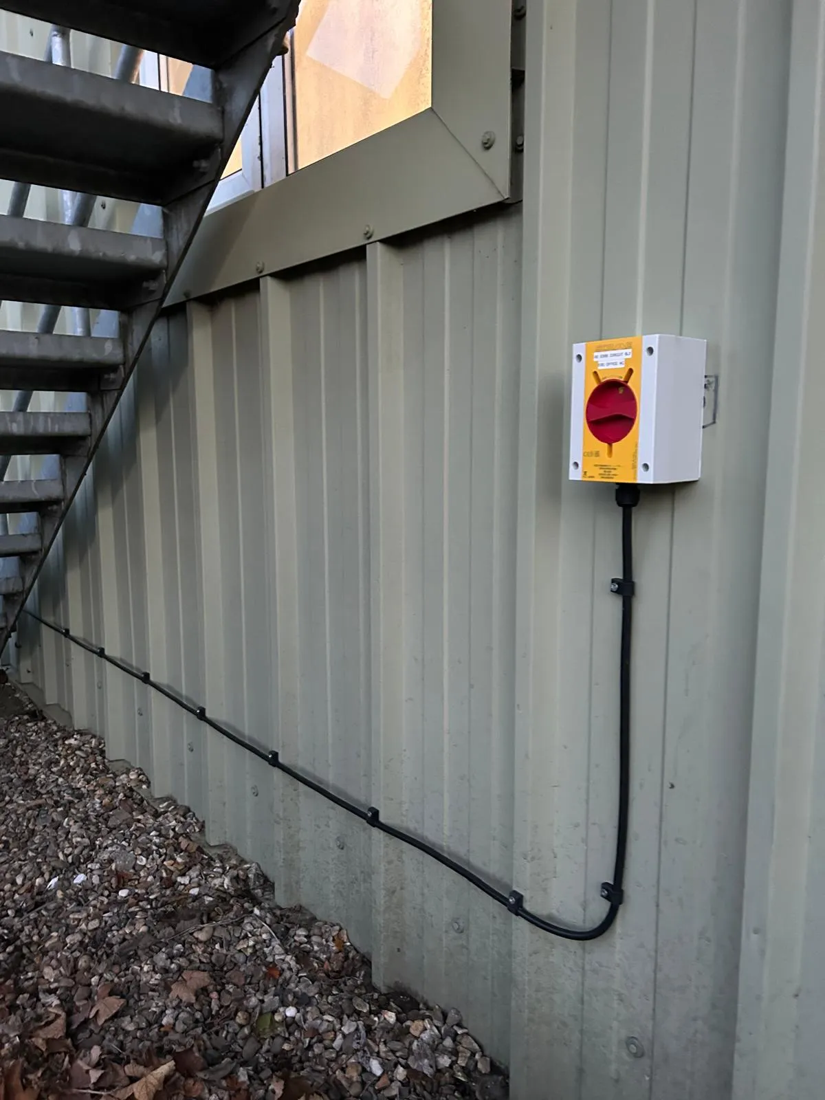 a red and white light switch on a metal wall